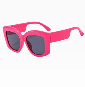 Detail view of bold pink oversized square sunglasses with thick temples and dark lenses