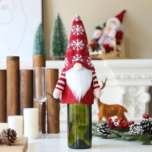 Detail of Christmas wine bottle cover with snowflake knit hat and gnome beard decor