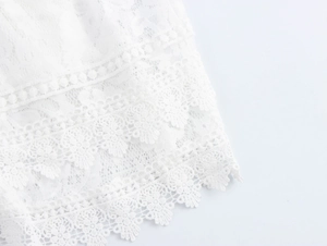 Gros plan détaillé sur la broderie en dentelle blanche française et la texture ajourée