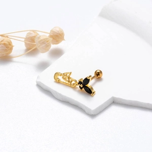 Detail of gold safety pin stud earring featuring a black butterfly with sparkling stones