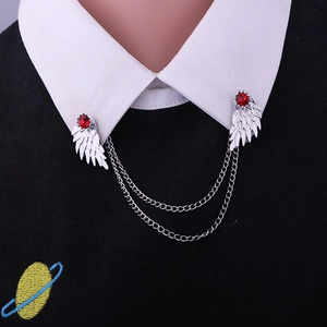 Close-up of wing-shaped collar pins with red rhinestones and hanging chains on shirt