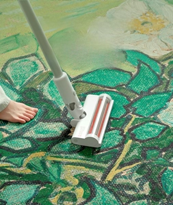Detail view of floral print rug showing its cleaning process with a vacuum cleaner