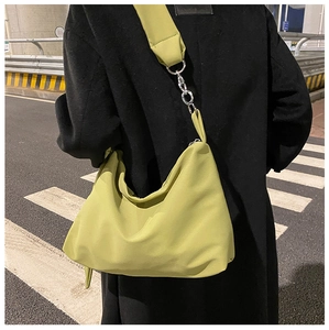 Close-up of lime green nylon crescent bag with silver metal chain strap detail