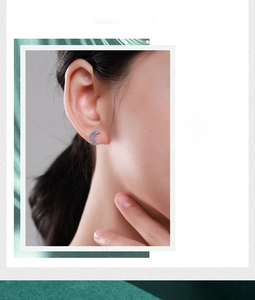 Detailed view of silver moon stud earrings with blue turquoise stones on model
