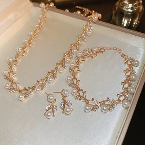 Detail of gold leaf-shaped jewelry set with white pearls and sparkling rhinestones