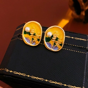 Detail of vintage oval gold-toned earrings with floral enamel and small pearls