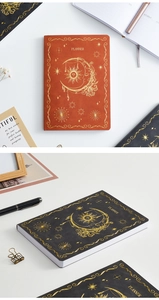 Detailed view of leather planner covers with gold foil sun and moon celestial patterns