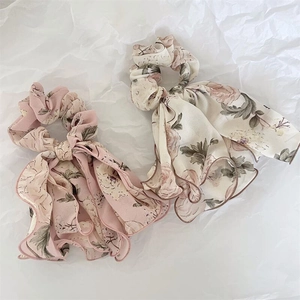 Détail de chouchous en mousseline florale avec rubans en rose et beige à motifs de roses