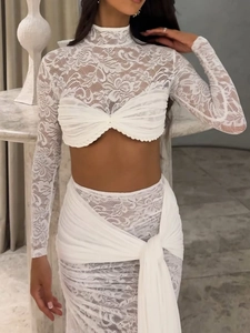 Detail of white lace two-piece set with long sleeves and crossover waist tie skirt