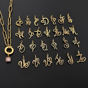 Macro view of 26 cursive alphabet heart pendants and pink stone necklace details.