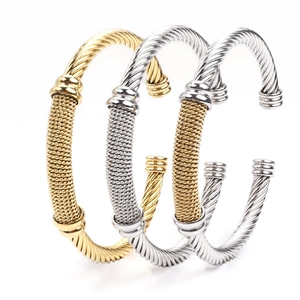 Stack of three twisted cable cuff bracelets in gold, silver, and two-tone steel finishes