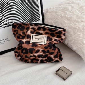 Dettaglio di una trousse leopardata con etichetta in tessuto Pleasant Time ricamata