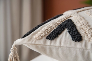 Macro shot of Moroccan tufted cushion cover with black and white embroidery and tassels