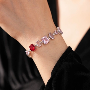 Close-up of French vintage zircon bracelet with pink and red gemstones on wrist