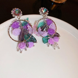 Boucles d'oreilles vintage avec roses mauves et papillons sur plateau blanc