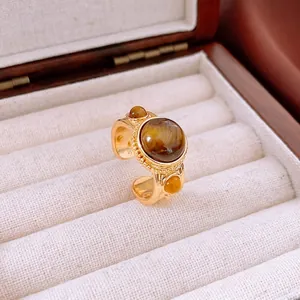 Anello vintage regolabile in occhio di tigre placcato oro su un espositore per gioielli