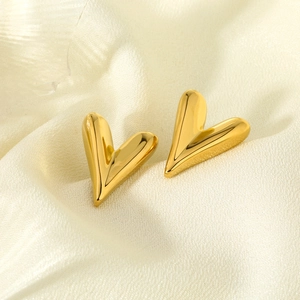 Polished heart-shaped 316L stainless steel earrings in 16K gold finish on silk