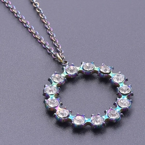Macro shot of circular rainbow plated stainless steel pendant with white crystals