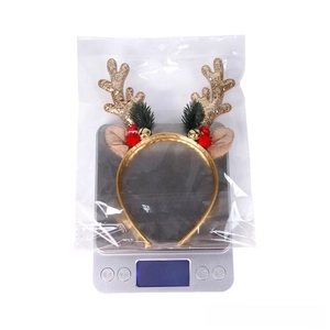 Detailed view of festive gold antler headband with bells on an electronic scale