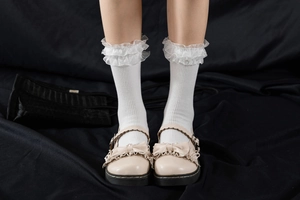 Détail de chaussettes Lolita blanches à volants d'organza et chaussures Mary Jane à nœuds