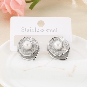 Detail of silver stainless steel shell earrings with white pearl and wavy texture