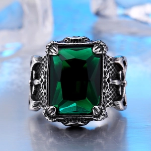 Macro shot of gothic silver ring featuring emerald cut green gemstone with vintage texture