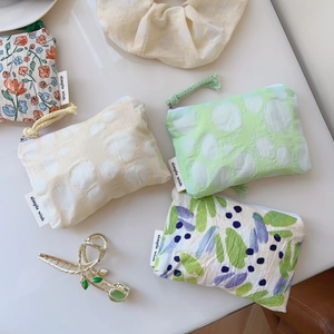 Vue à plat de petits sacs en coton fleuri avec fermeture éclair et cordons colorés
