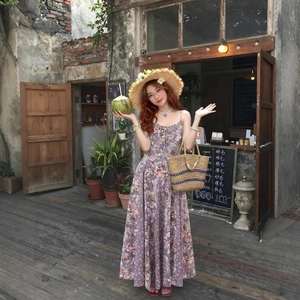 Robe longue bohème à fleurs violettes et roses avec chapeau de paille et cabas