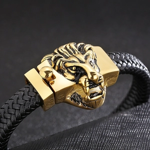 Détail macro du fermoir tête de lion doré et du bracelet en cuir tressé noir pour homme