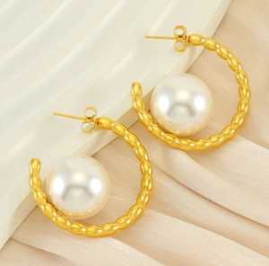 Detail of 18k gold plated chunky hoop earrings with pearls on silk fabric background