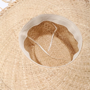 Detailed close-up of straw hat interior showing woven texture and adjustable drawstrings