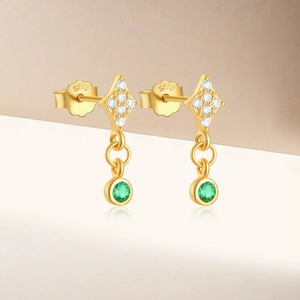 Detail of S925 silver gold-plated diamond earrings with elegant green gemstone drops