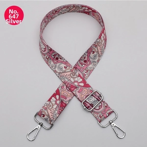 Macro detail of bohemian floral patterned 38mm wide bag strap with silver metal swivel hooks