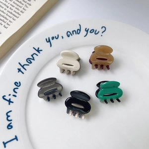 Five-piece mini acetate hair claw set in multi-color heart shapes on white plate