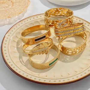 Set of six gold plated stainless steel bangles with gemstone accents and hollow patterns