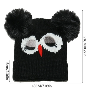 Size chart of black knit beanie with double pompoms and owl face design details