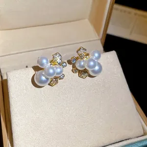 Élégantes boucles d'oreilles fleurs dorées avec perles blanches et zircons brillants