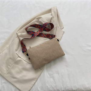 Detailed view of bohemian crossbody bag with colorful ethnic pattern strap on blazer