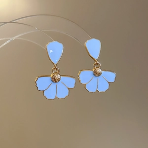 Macro view of blue enamel flower earrings with gold plating and fine drip oil detailing