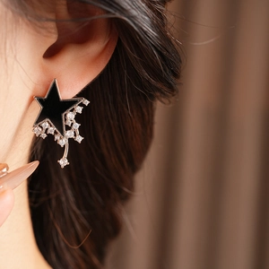Close-up of star stud earring with white zircon fringe on model ear in rose gold finish