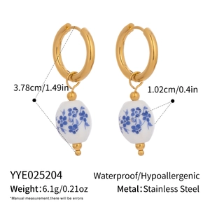 Detailed view of enamel floral earrings with blue and white beads and precise size markings