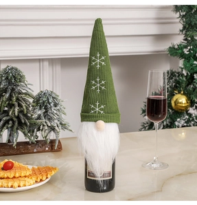 Close-up of green knitted gnome wine bottle cover with snowflake pattern and white beard