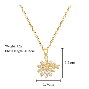 Close-up of gold titanium necklace featuring sparkling daisy flower and dragonfly pendant