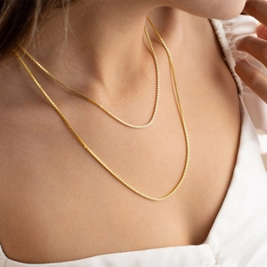 Elegant gold-plated stainless steel box chain necklace layered on a female model