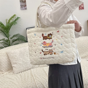 Quilted tote bag detail featuring cute animal embroidery and heart-shaped stitching