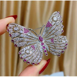 Elegante broche de mariposa con piedras rubí y circonitas blancas en seda dorada