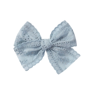 Close-up of light blue lace bow clip with delicate floral hollow embroidery textures