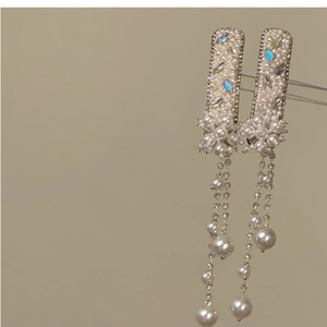 Detail of luxury pearl and rhinestone fringe hair clip with elegant tassel design