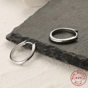 Minimalist S925 sterling silver oval hoop earrings on natural black slate background