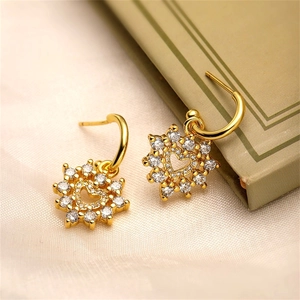 Detailed macro view of heart-shaped sunflower earrings with sparkling zircon crystals
